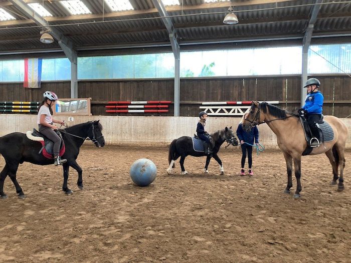Kinder spielen während der Ferien Ponyhof einige lustige Reitspiele