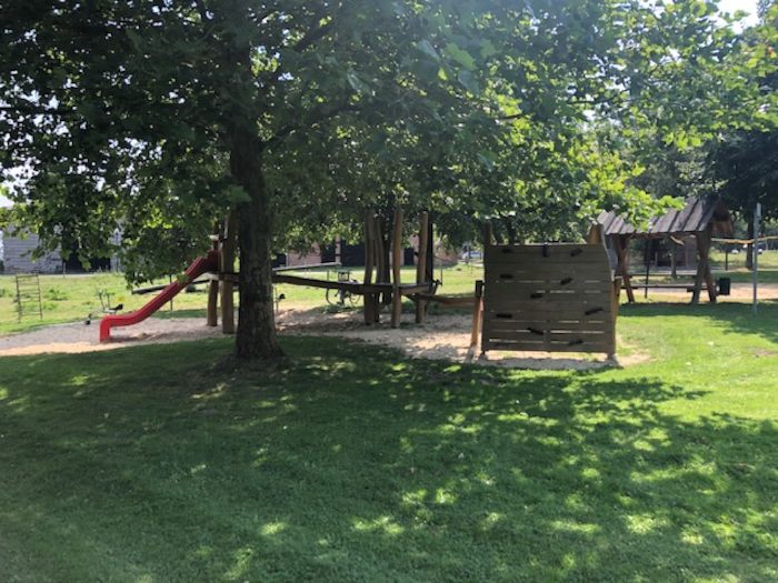 Der Spielplatz während der Ferien auf dem Ponyhof liegt direkt neben einer grünen Wiese