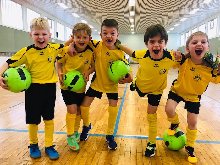 Teilnehmer eines Fußballcamps spielen in der Halle