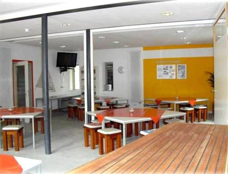 Im Essensraum vom Windsurfcamp stehen einige Tische und ein TV.