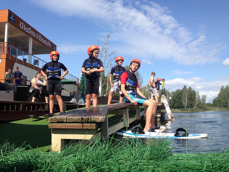 Ein Junge eines Wakeboard Camps lässt die Beine baumeln