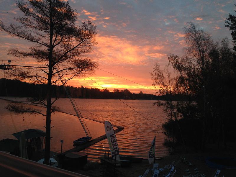 Man sieht die Anlage eines Wakeboard-Camps bei Sonnenuntergang