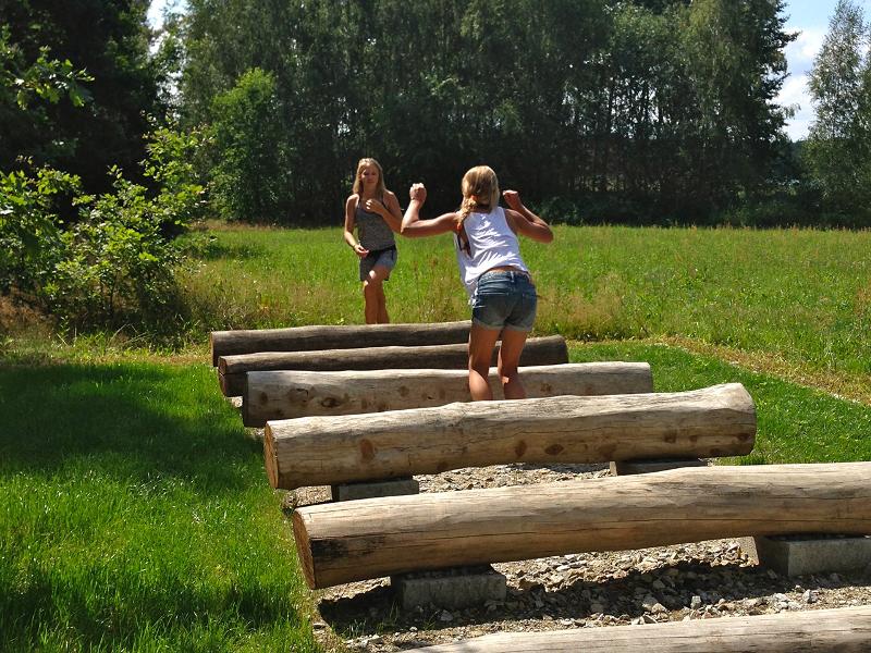 Kinder eines Wakeboard-Camps springen über Stämme