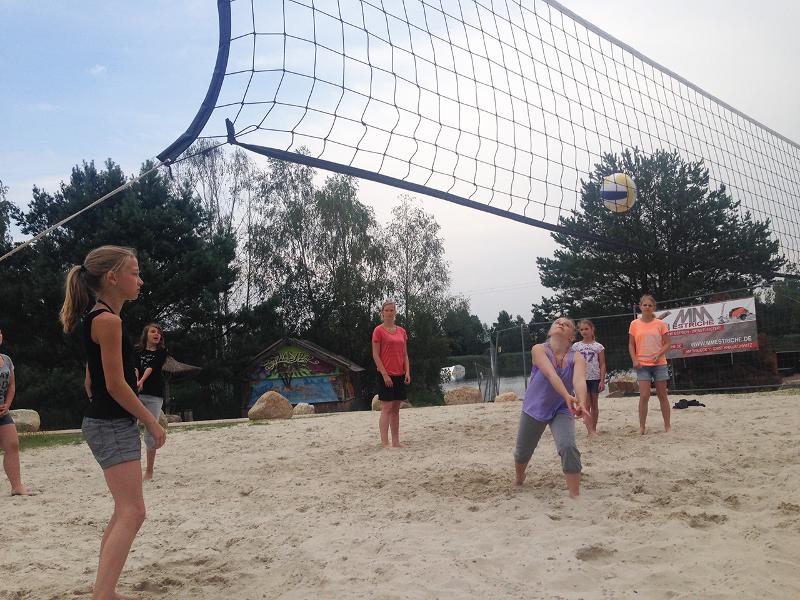 Teilnehmer eines Wakeboard-Camps spielen Volleyball