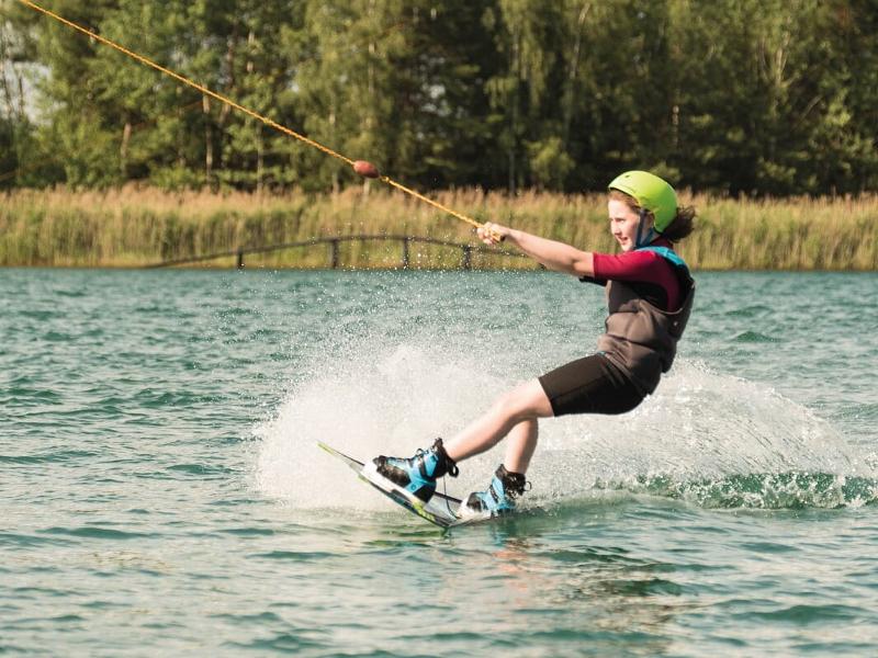 Ein Junge eines Wakeboard-Camps fährt Wakeboard
