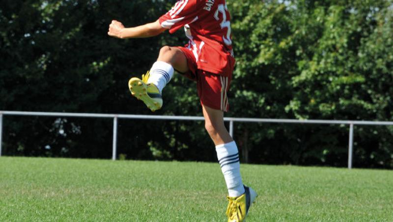Ein Junge hat gerade einen Ball im Fußballcamp geschossen