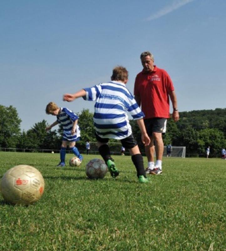 Bei einer Übung trainieren die Kinder im Fußballcamp den Ball am Fuß zu halten