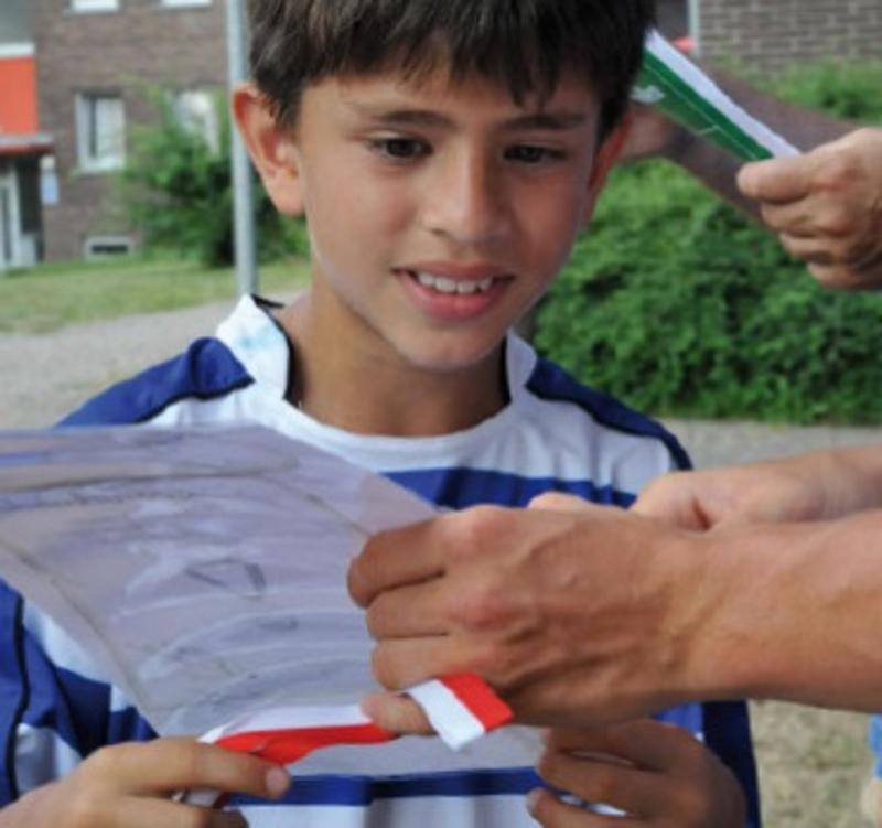 Ein Kind bekommt im Fußballcamp eine Urkunde