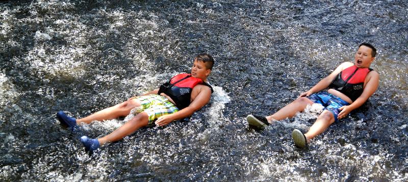 Im Abenteuer Ferienlager liegen zwei Jungs in einem Fluss.