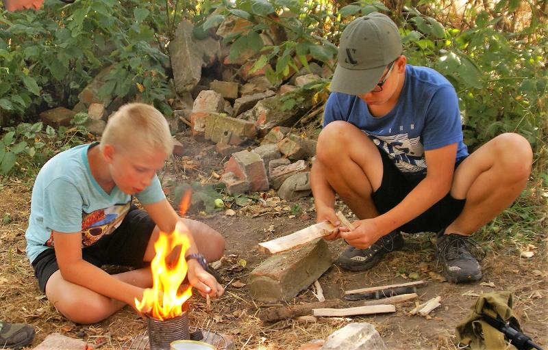 Die Kinder probieren im Abenteuer-Camp Feuer zu machen, ganz ohne Feuerzeug natürlich.