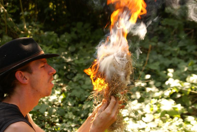 Ein Betreuer macht im Abenteuer Ferienlager Feuer.
