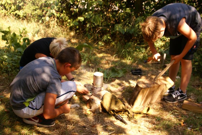 Die Kinder im Abenteuercamp werkeln mit Holz rum.
