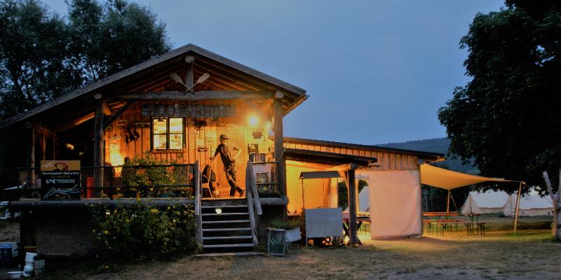 Ein Betreuer steht vor dem Haus, welches als Unterkunft fürs Abenteuer-Camp genutzt wird.