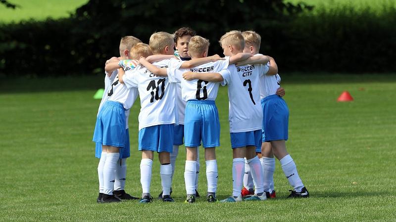 Kinder einer Fußball-Schule Ferien motivieren sich