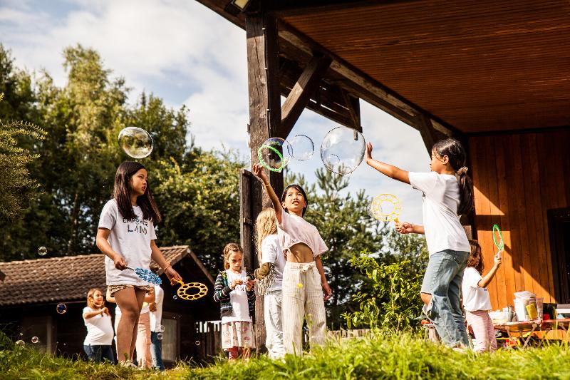Die Kinder des Osterferienprogramms spielen mit Seifenblasen