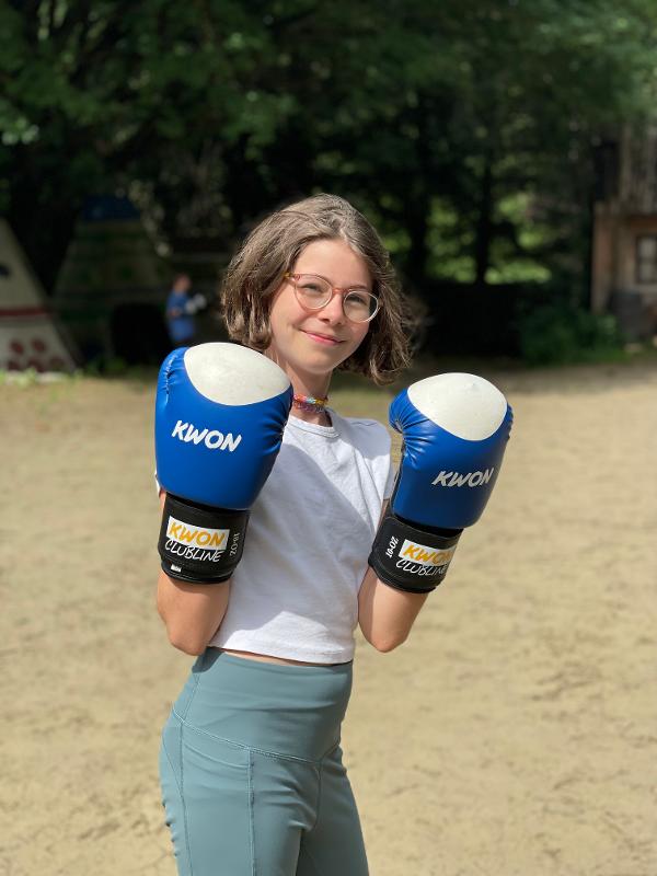 Eine Teilnehmerin im Ferienangebot Bayern trägt blaue Handschuhe