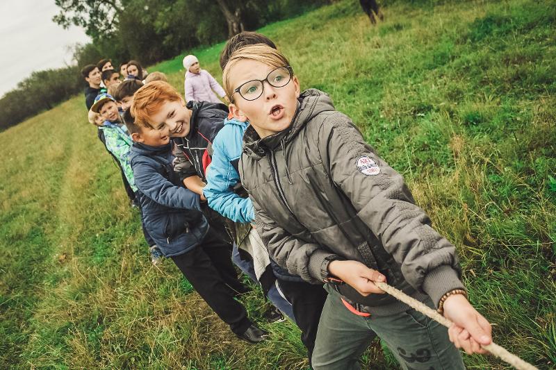 Kinder des Herbstferienprogramms München spielen Tau ziehen