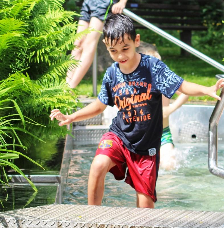 Ein Junge eines Handball Camps spielt im Wasser