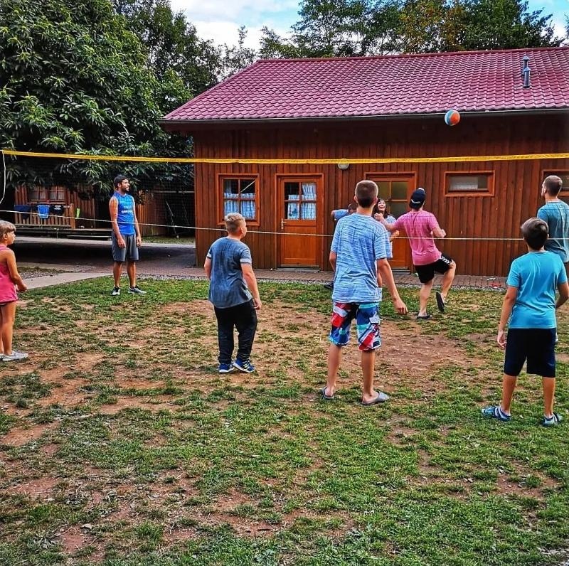 Kinder eines Handball Camps speilen Volleyball