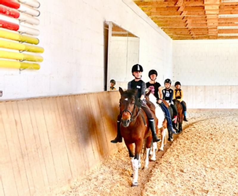 Kinder der Reiterferien für Kinder reiten in der Halle