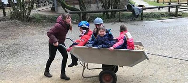 Kinder der Reiterferien für Kinder sind in der Schubkarre