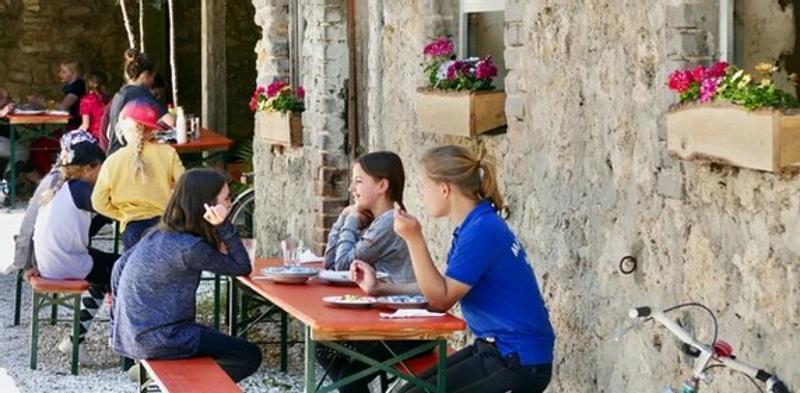 Kinder der Reiterferien für Kinder essen auf dem Hof