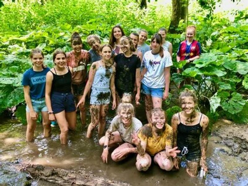 Kinder der Reiterferien für Kinder sitzen im Matsch