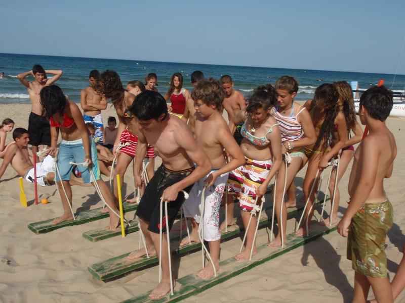 Teilnehmer eines Feriencamps am Wasser spielen am Strand