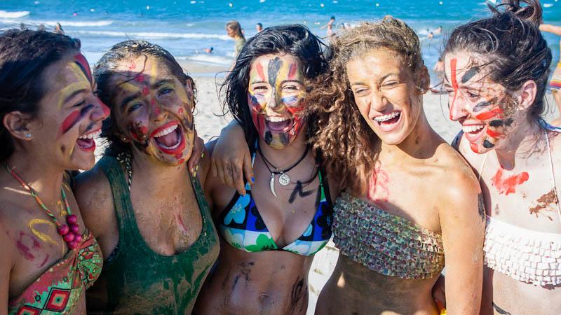 Teilnehmer eines Feriencamps am Wasser haben Bodypaint am Körper