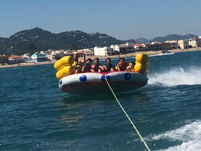 Jugendliche eines Wasserski-Camps werden auf einem Schlauchboot übers Meer gezogen