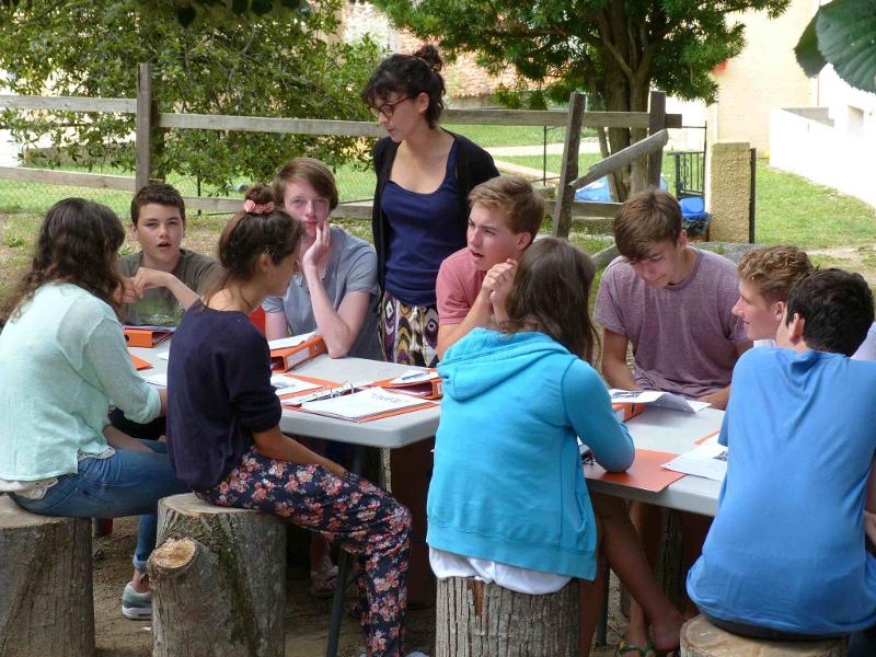 Schüler sitzen bei einer Frankreich Sprachreise draußen an einem Tisch