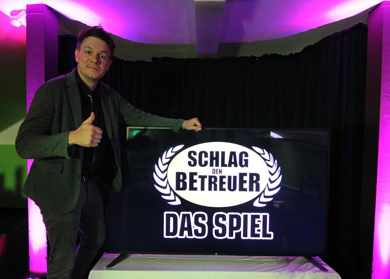 Ein Betreuer steht vor einem Banner im Feriencamp Bremen