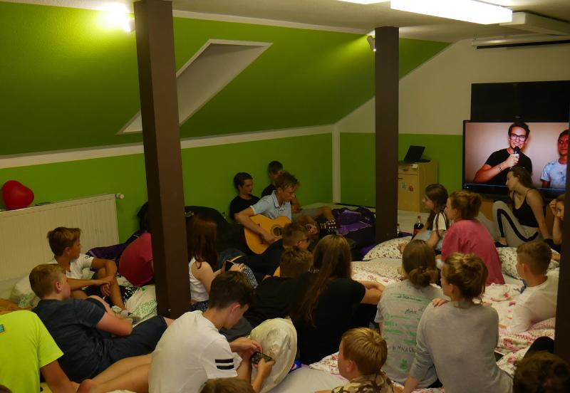Teilnehmer veranstalten im Feriencamp Bremen einen Filmeabend und spielen Gitarre