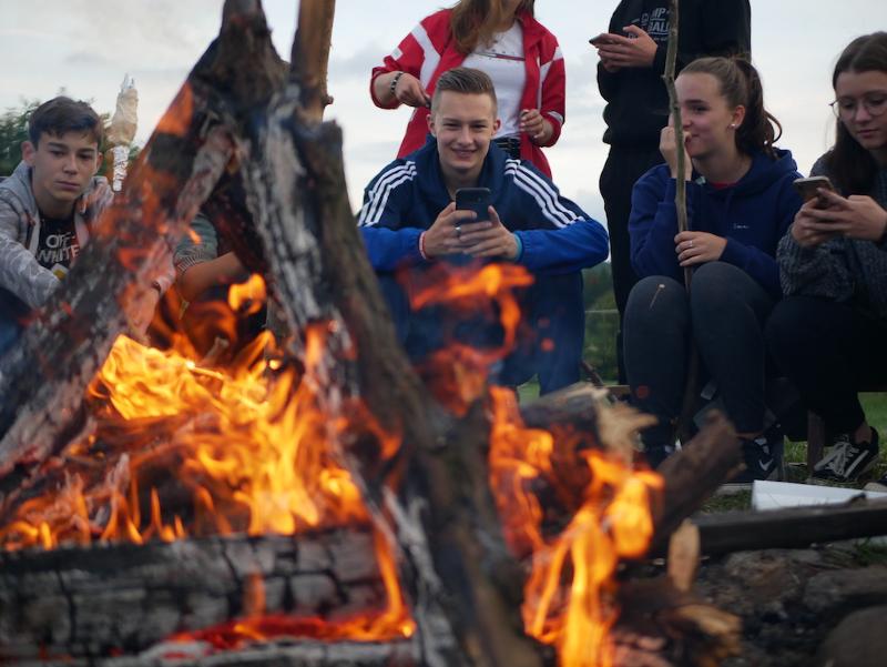 Teilnehmer der Jugendreise ab Berlin sitzen am Lagerfeuer