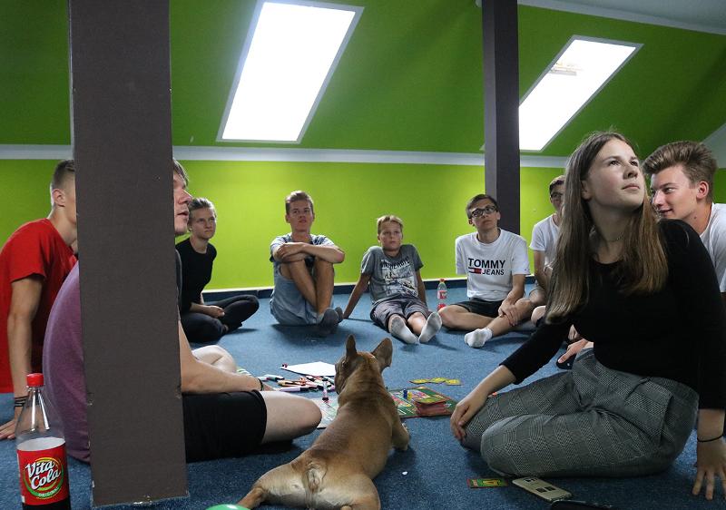 Teilnehmer eines Feriencamp München sitzen in einem Sitzkreis