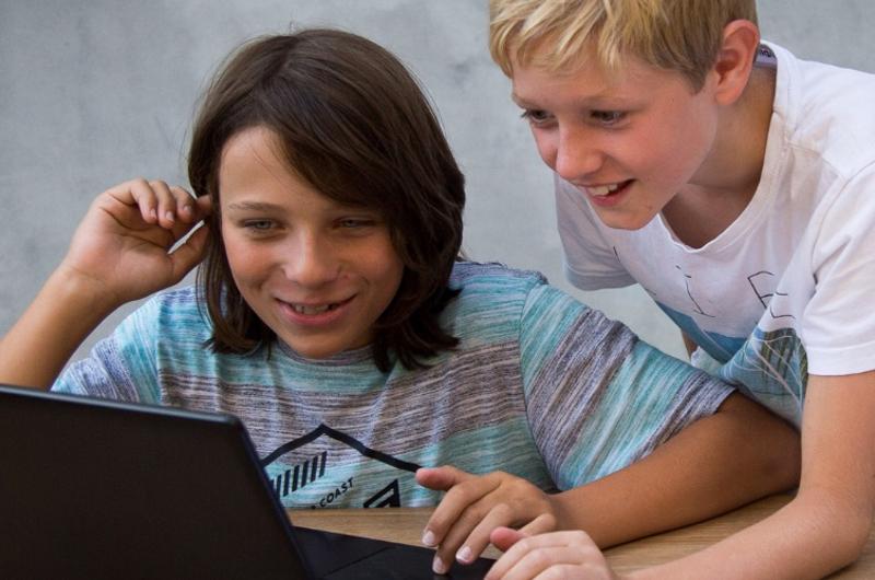 Teilnehmer eines Forschercamps helfen sich