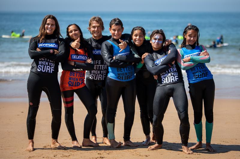 Eine Gruppe von Jugendlichen Surfern steht im Portugal Surfcamp am Strand