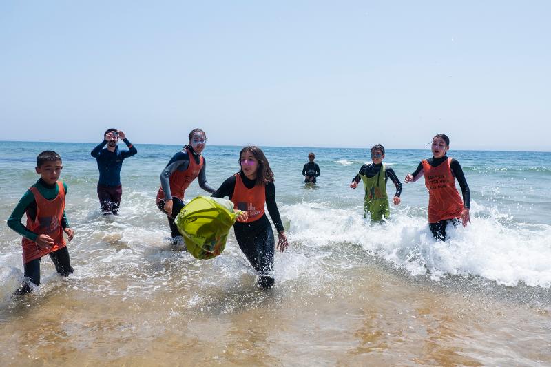 Teilnehmer eines Surfcamps spielen im Wasser