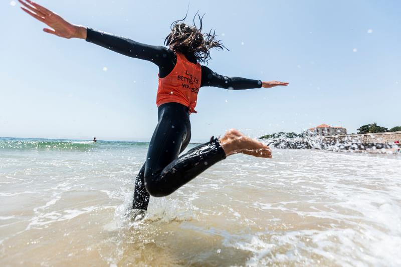 Ein Mädchen im Surfcamp Kinder Deutschland läuft durchs Wasser