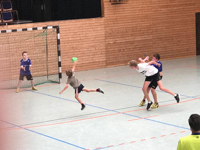 Ein Junge im Handball Camp wirft einen Ball