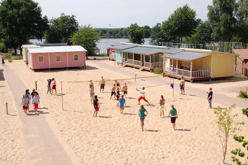 Teilnehmer eines Wakeboard Camps spielen Beachvolleyball