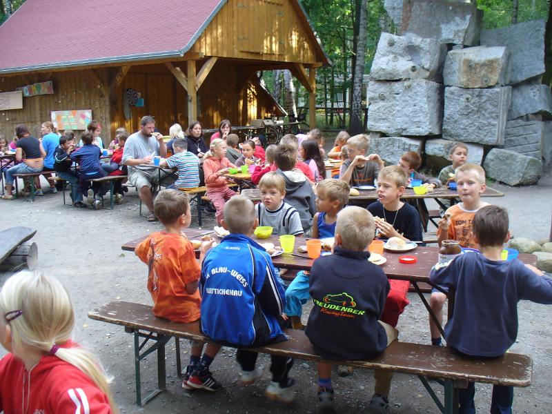 Die Kinder essen gemeinsam während der Ferienbetreuung Mittag