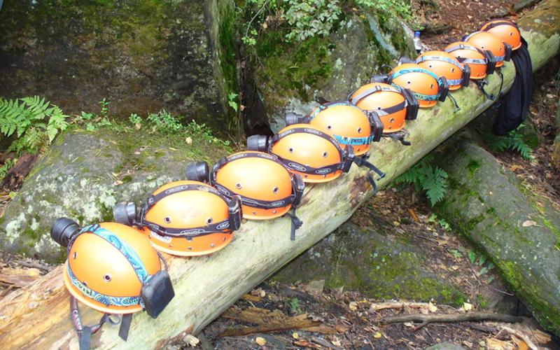Viele Helme liegen in der Ferienbetreuung nebeneinander auf einem Baumstamm