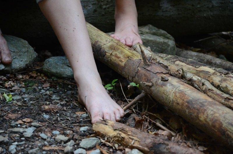Ein Teilnehmer eines Abenteuer Forschercamps läuft Barfuß