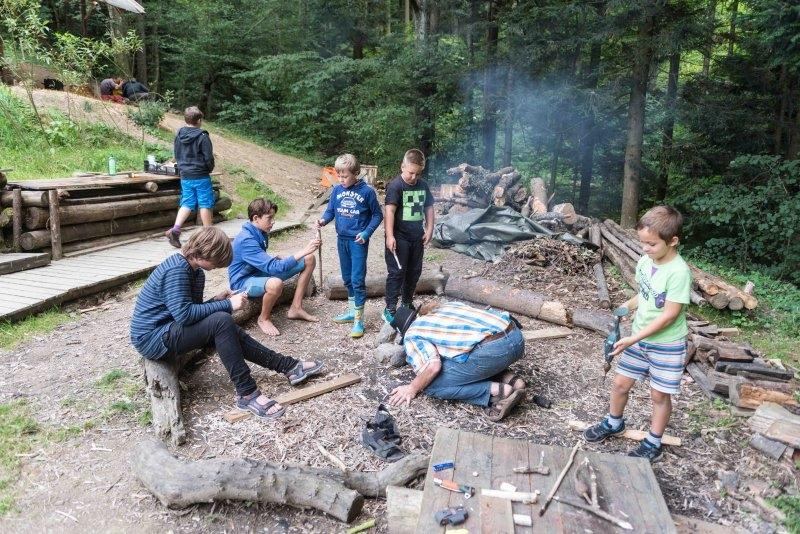 Kinder eines Abenteuer Forschercamps machen Feuer