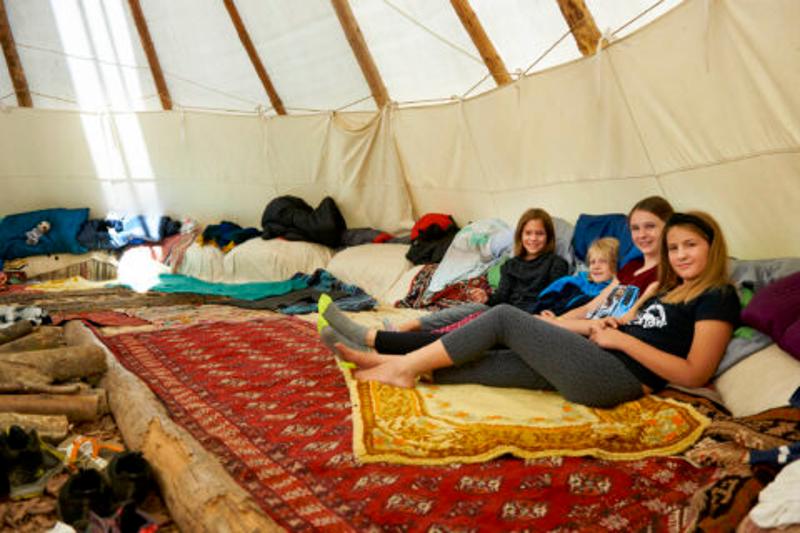 Kinder eines Feriencamps der Sommerferien Essen liegen zusammen im Zelt