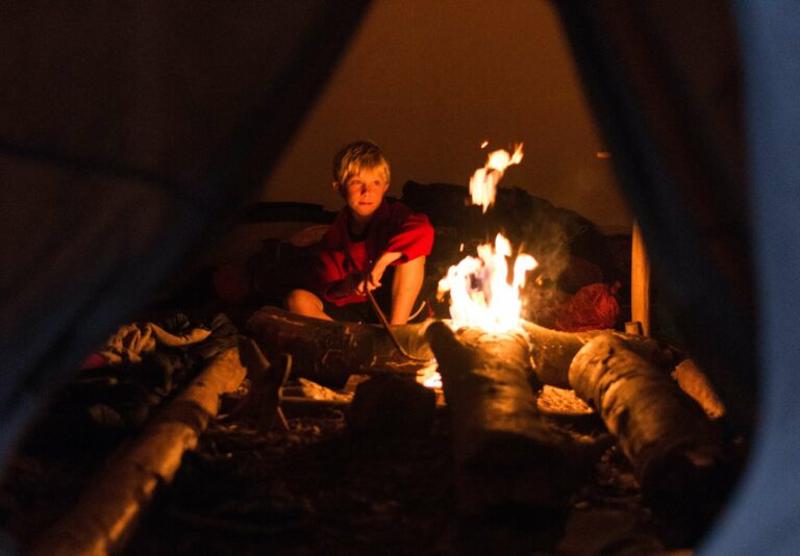 Im Sommercamp Wien sitzen die Kinder am Lagerfeuer