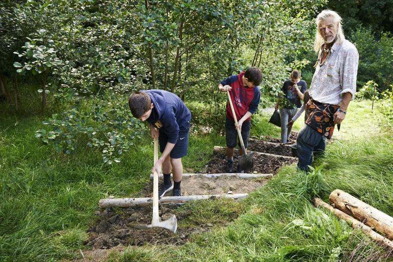 Kinder des Sommercamps Wien arbeiten mit Schaufel in der Natur