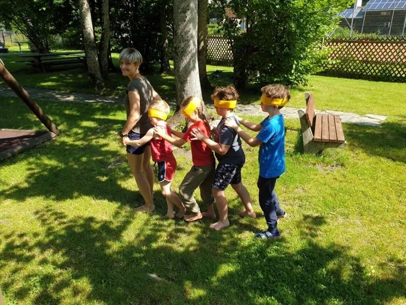 Teilnehmer eines Sportlagers spielen blinde Kuh