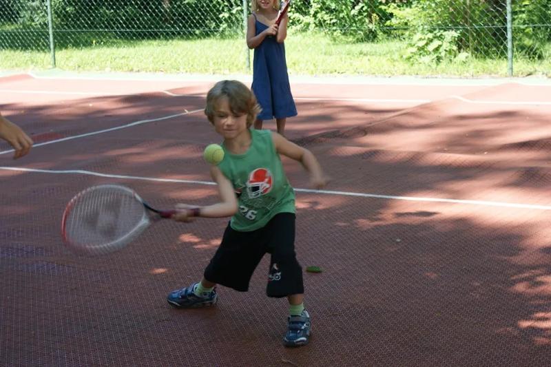 Teilnehmer eines Sportlagers spielen Tennis